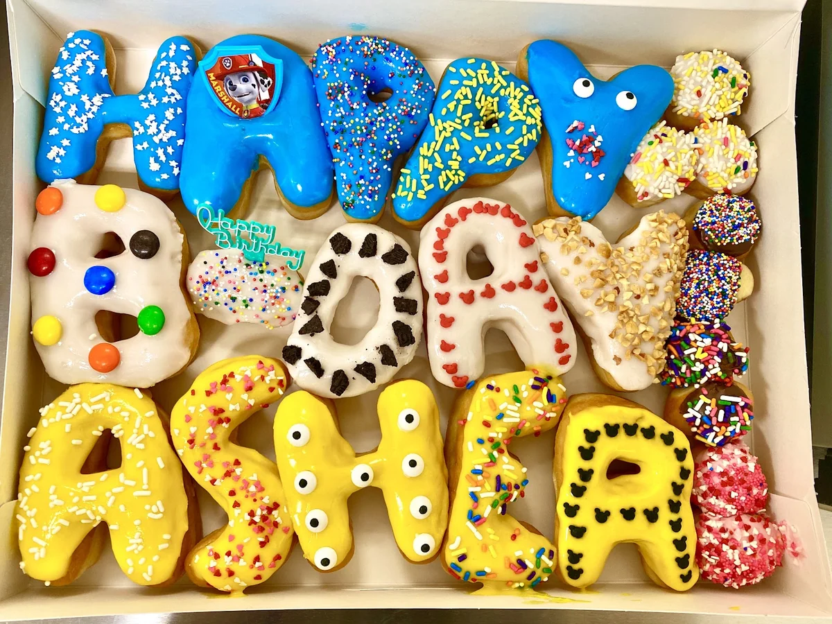 Custom Happy Birthday name donuts in bright colors with character toppers